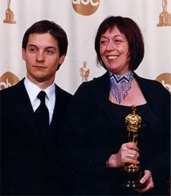 Principal Christine, an Oscar and award-winning makeup artist, receiving the Academy Award for hair and makeup from actor Tobey Maguire, known for his role as Spider-Man.